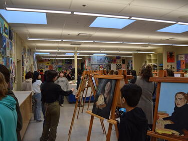 Art displays set up for Art show. Students walking around looking at art pieces