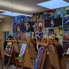 Art displays set up for Art show. Students walking around looking at art pieces