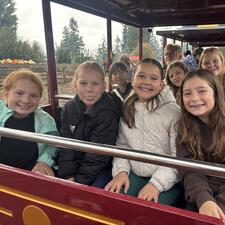 Elementary students sitting on a train waiting to go for a ride.